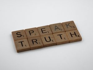 Letter blocks spelling out the phrase "speak truth". 