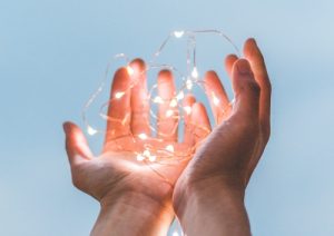 Hands holding string of white lit LED lights