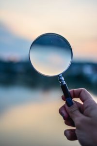 Hand holding magnifying glass