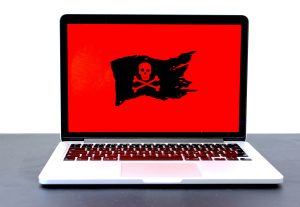 Computer with red background and black pirate flag.