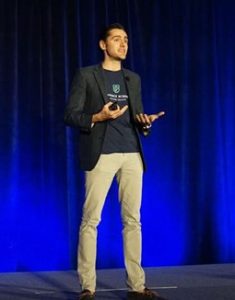 a person standing on a stage with a blue background