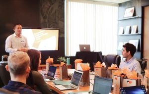 PICTURE OF BOARD ROOM WITH SPEAKER AT THE HEAD OF THE TABLE