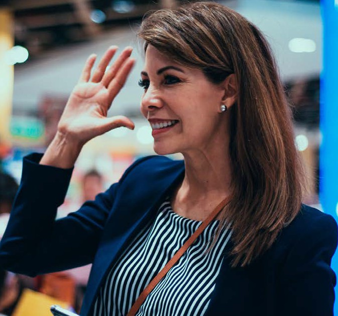 image of a woman raising her hand and smiling
