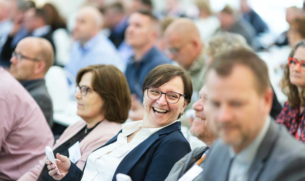 image of a large audience smiling at each other