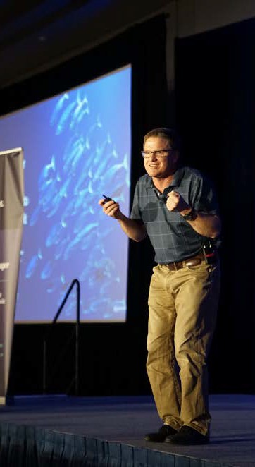 image of a man on stage leaning forward with emphasis