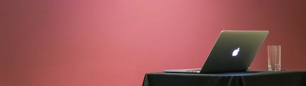 image of a red background with a laptop and glass of water