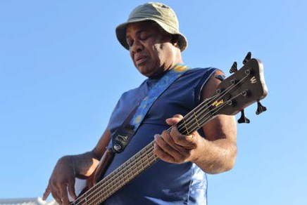 image of a man outside playing a bass guitar
