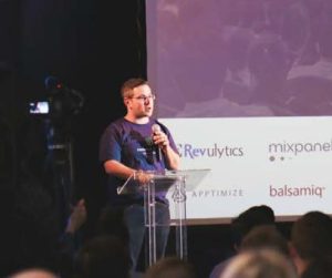 image of person holding a microphone and standing in front of a lectern