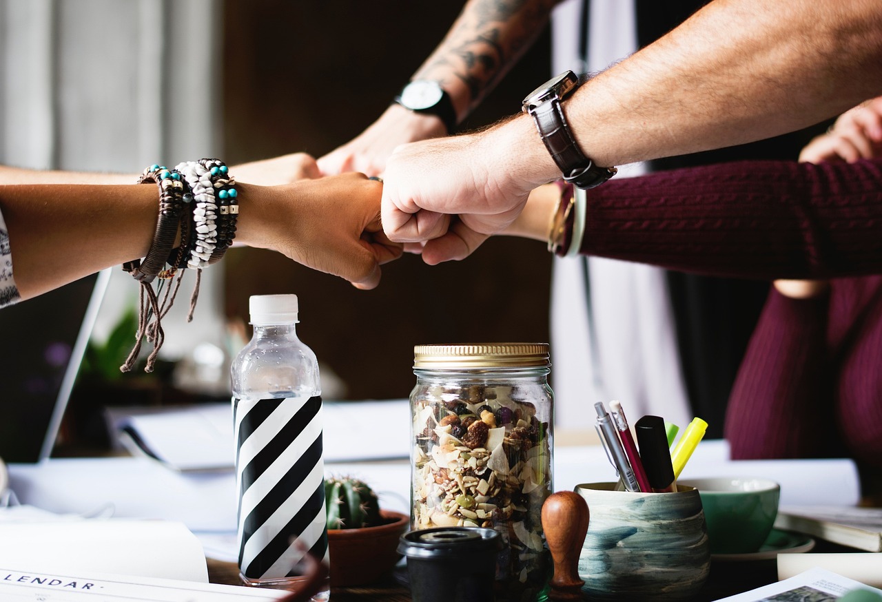 Many hands connected with fist bumps.