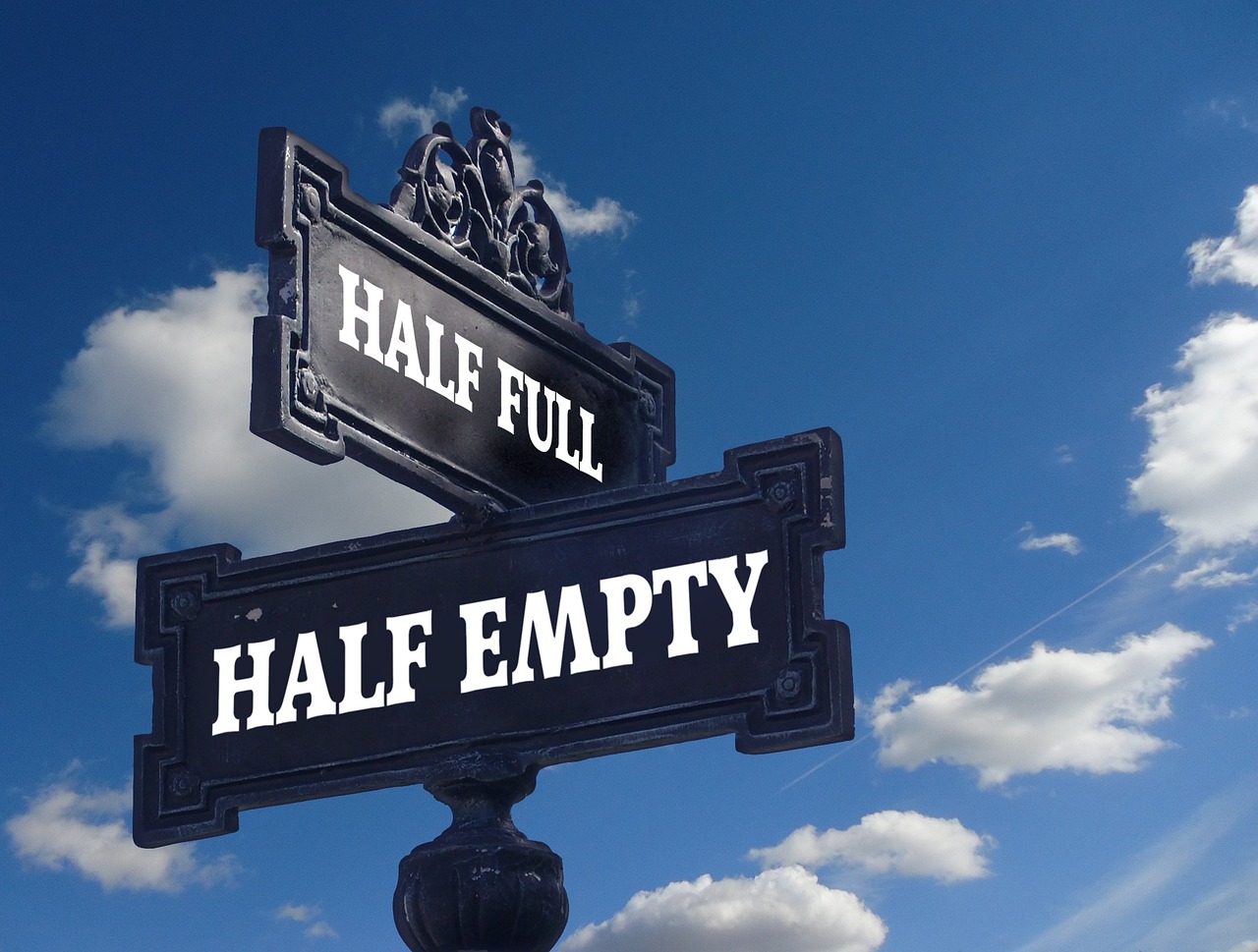 Road sign noting one way is half empty and the other is half full.